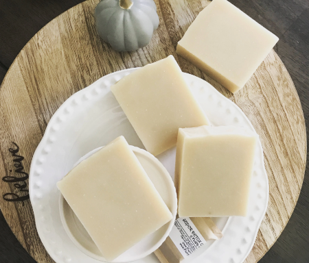 Goatmilk Soap with oatmeal on a wooden platter on white plate
