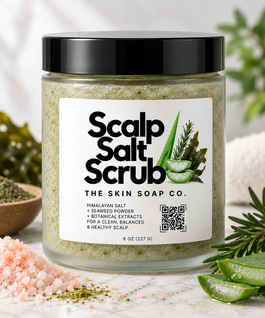 A jar of Scalp Salt Scrub by The Skin Soap Co. filled with a light green scrub, featuring a black lid and a white label with green aloe vera graphics.